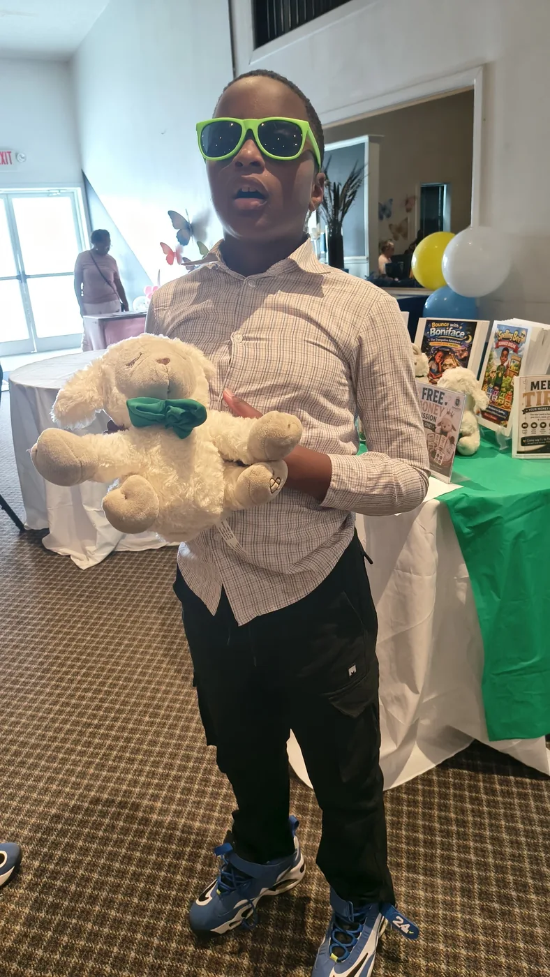 Enfant tenant fièrement la peluche Tiro l'agneau au Book Expo 2026